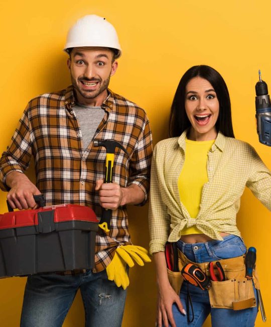 excited-handywoman-and-handyman-holding-toolbox-and-electric-drill-on-yellow.jpg